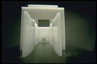 A white corridor leading under an archway